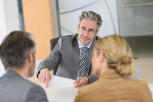 Mature couple signing contract in lawyer's office