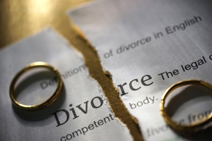 A ripped divorce contract with two rings on it representing divorce attorneys in Peoria IL