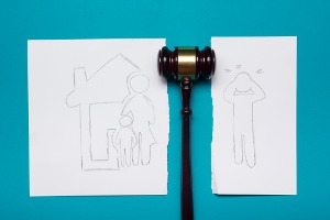 A drawn picture of divorce in Pekin IL featuring a mother and child with the father ripped separate and a gavel in between the two