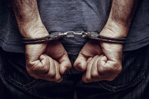 A man in handcuffs who will need a Criminal Defense Lawyer in East Peoria IL