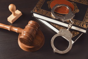 Handcuffs, a gavel, and law books regarding Larceny in Dunlap IL